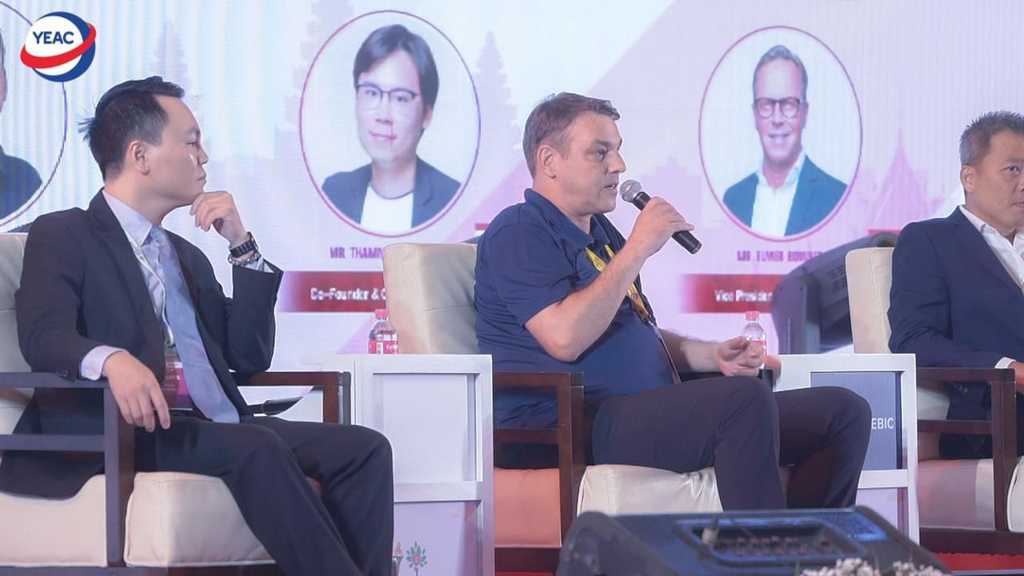 Gregor Zebic speaking on a panel discussion holding a microphone